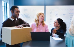 Man with packaging, talking to colleagues
