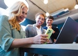 Three colleagues around a laptop and phone