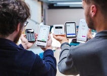 Two people presenting a range of card machine readers