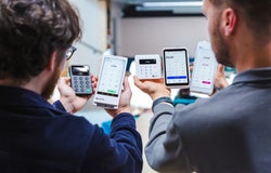 Two people presenting a range of card machine readers