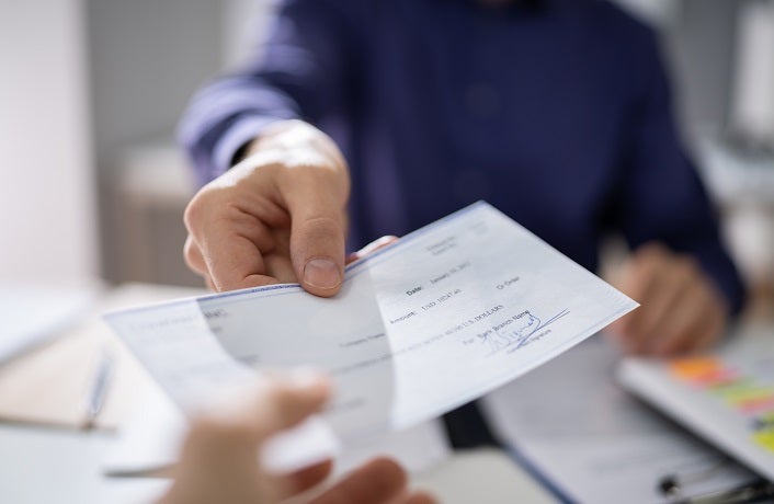 Businessperson Hands Giving Cheque To Other Person