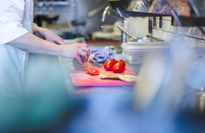 A chef prepares fresh vegetables on a chopping board