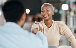 Black, female woman shaking hands with white male to seal an agreement
