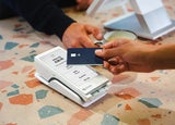 A person taps their payment card on a POS device