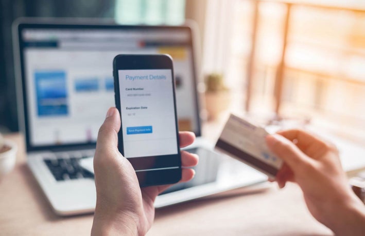 Person setting up a payment using their debit card and phone