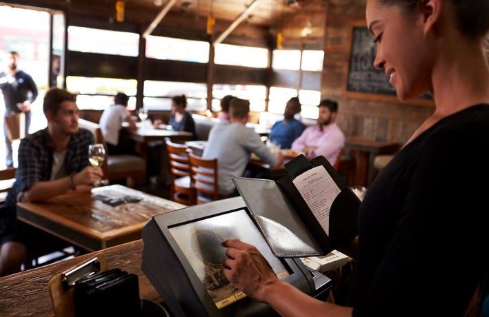 Restaurant staff member preparing a bill