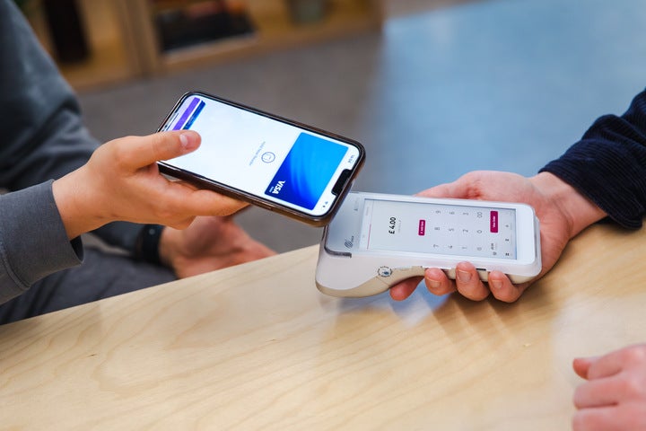 A close-up of someone taking a card payment with a white Take Payments Plus card reader