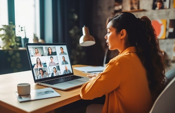 Back view of female employee talking on video call with colleagues. Working from home concept. Generative AI